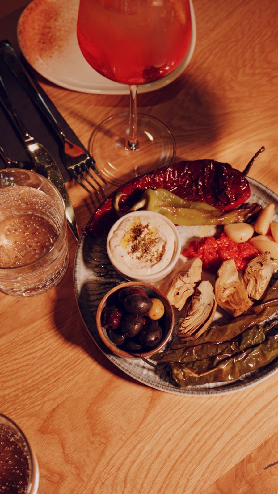 Teller zum Teilen mit einem Glas Wein auf dunklem Tisch