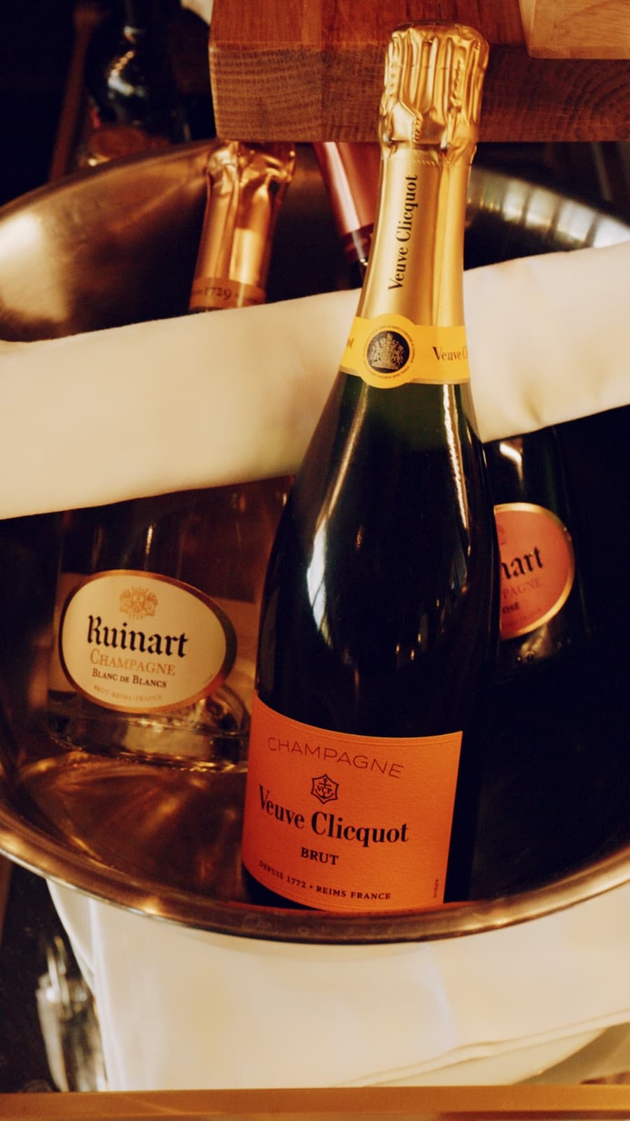 Weinflaschen und Champagner im Eiskübel auf dem Tisch